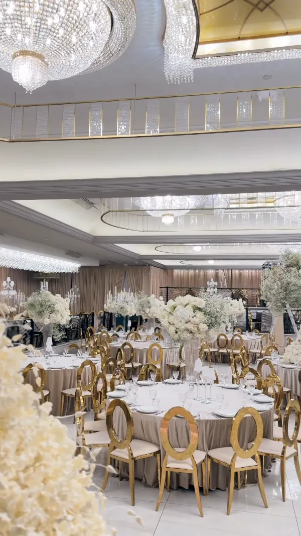 The Arbat ballroom with crystal chandeliers, gold chairs and round tables set for a celebration